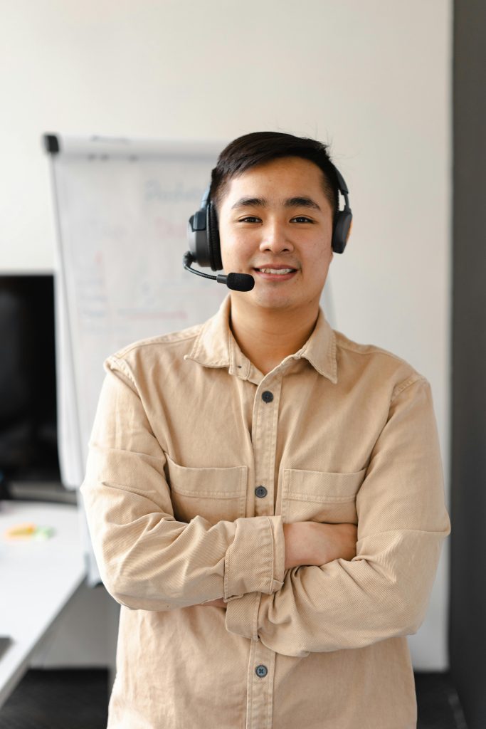 Professional customer service agent smiling while wearing a headset, ready to assist.